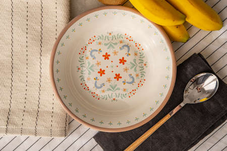 Enamel plate with decoration on a table with fruits.の写真素材