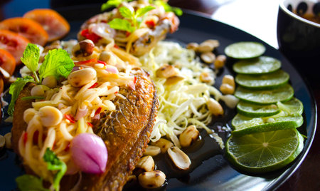 Fried fish with vegetables and salad, spicy food ingredient division Thailandの写真素材