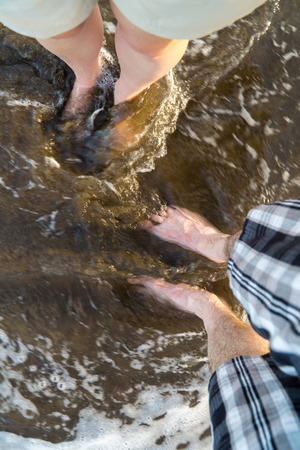 Selfie of man and woman bare feet on sand beach and wave, summer conceptの写真素材