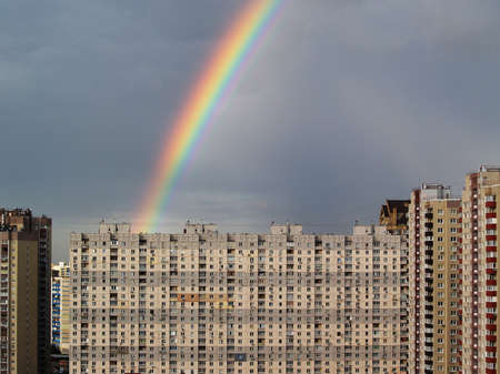 Rainbow in the grey sky above the cityの写真素材