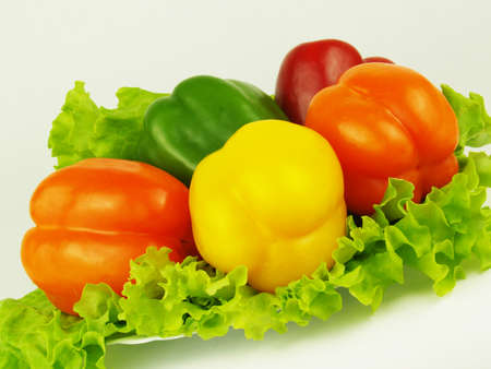 Colored peppers with fresh green salad on the white plate     の写真素材