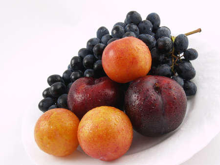 Fresh fruits on the white plate on the white backgroundの写真素材