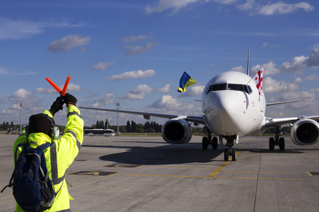 Borispol, Ukraine - October 05, 2018: Meeting at the Borispol International Airport. A supervisor helps at the aircraft parkingのeditorial素材