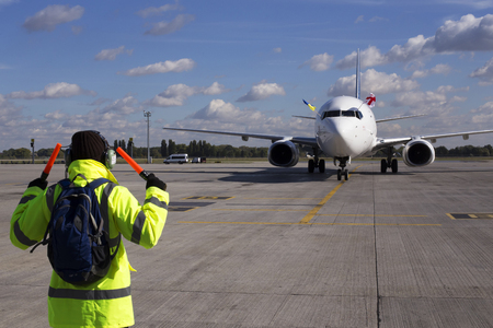 Borispol, Ukraine - October 05, 2018: Meeting at the Borispol International Airport. A supervisor helps at the aircraft parkingのeditorial素材
