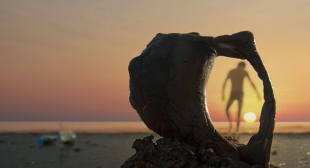 shot taken at Atlantic ocean, men walking away and playing with the sunの写真素材