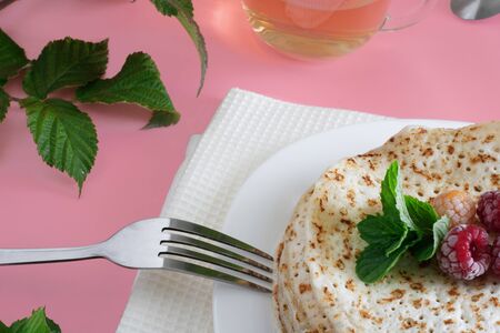Fried pancakes close-up on a white plate, pancakes with raspberries, tea cerimonia, dessert on a pink background, foodの写真素材