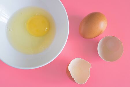 chicken eggs, white plate with chicken egg on a pink background, creative minimal concept. Creative...