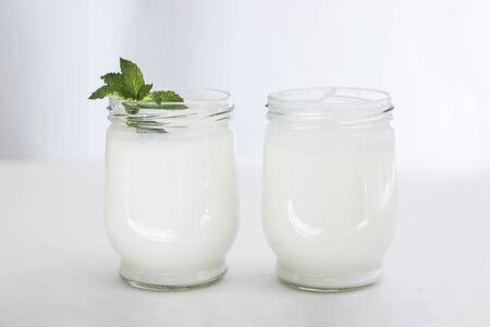 Organic probiotic milk kefir drink or yogurt in glass containers,on the white grey background. Gut health. Probiotic cold fermented dairy drink. Trendy food and drink. Copy spaceの写真素材
