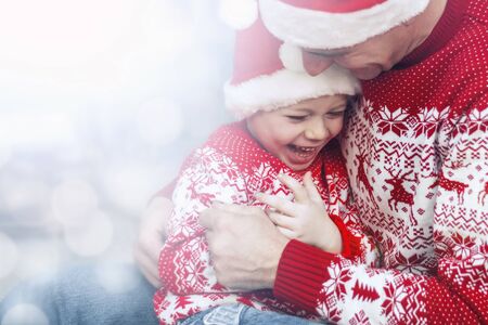 Happy family. Father and baby son celebrate Christmas at home. Magic atmosphere family holidays. Concept Christmas and New Year. Selective focus, bokeh. Copy spaceの写真素材