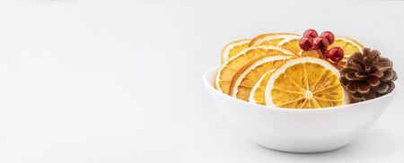 Eco organic homemade dried orange slices, chips with pine cone and christmas berries . Dehydrated crispy fruit slices. Healthy snack. Christmas and New Year card concept. Close up. Copy spaceの写真素材