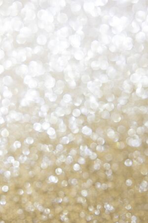 Bokeh, defocus background. Glare bokeh passing from silver white to gold. Festive background. Vertical orientation. Copy spaceの写真素材