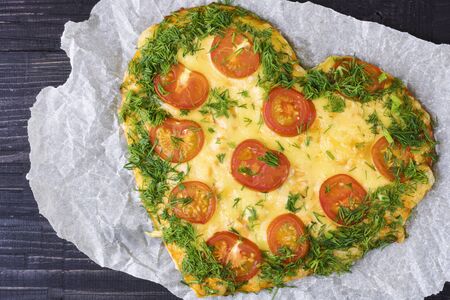 Valentines Day food. Heart shaped pizza with greens and mushrooms, vegetables on a dark background. Valentine's day concept. Top view. Copy spaceの写真素材