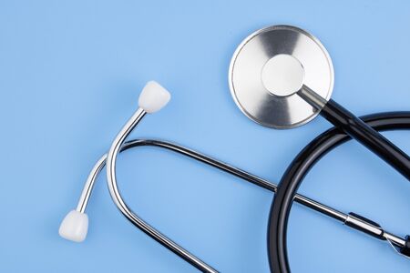 A stethoscope is isolated on a blue background. The concept of medical equipment, cardiology, lung...