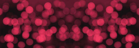 Defocused bokeh background. The red lights are defocused against a dark background. Christmas or New Years bokeh. Bannerの写真素材