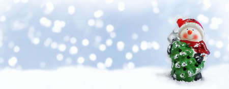 Happy snowman standing in winter christmas landscape. Merry christmas and happy new year greeting...