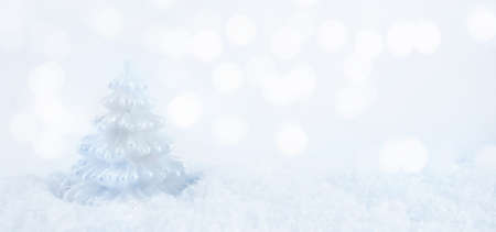 Christmas background. White Christmas tree with snow on a background of bokeh lights. Christmas and New Year concept. Copy spaceの写真素材