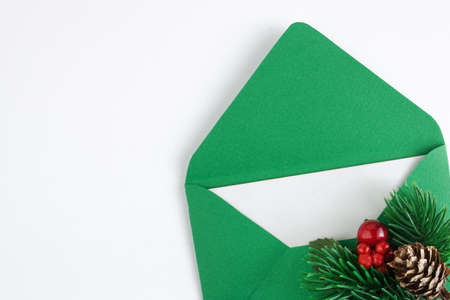 Green envelope with white sheet and Christmas branch isolated on white background. Christmas mail....