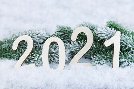 Text 2021 on the snow against the background of the branches of the Christmas tree. Christmas and New Years concept. Card. Copy spaceの写真素材