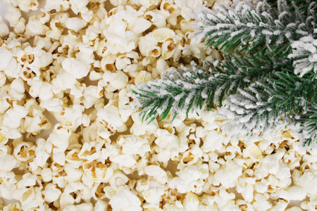Fresh popcorn background. Popcorn texture. Popcorn with Christmas branch, top view. Christmas or New Year concept. Selective focus. Corn snacks.の写真素材