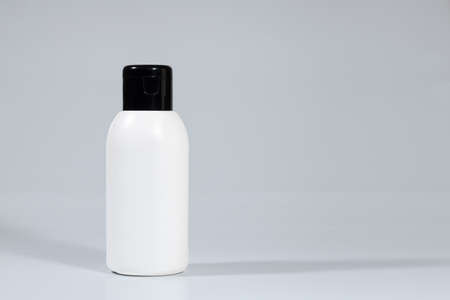 Skincare cosmetics bottles on white background, with a green plant. Spring season cosmetics. Daily cosmetics. Cosmetics advertisement mockup. Banner. Copy spaceの写真素材