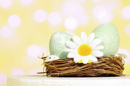 Easter background. Selective focus. Easter eggs in a nest or basket of flowers, on a yellow...