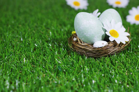Easter background. Selective focus. Easter eggs in a basket on a meadow with flowers. Easter card...