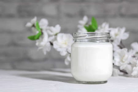 Organic probiotic milk kefir drink or Greek yogurt in glass jar, on the white gray background. Gut health. Probiotic cold fermented dairy drink. Trendy food and drink. Copy spaceの写真素材