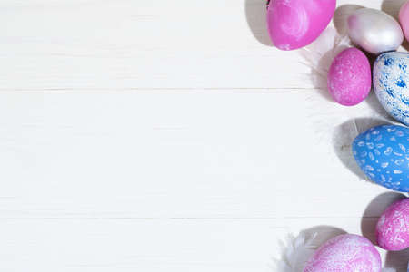 Collection of Easter eggs. Chicken eggs painted blue and pink lie on a white wooden background. Creative greeting card with Easter. Frame. Top view. Copy spaceの写真素材