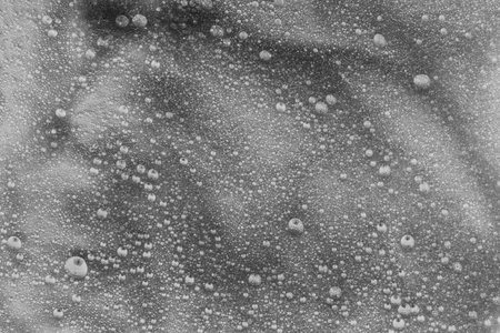 Moisturizing cosmetic product for skin care. The texture of the liquid transparent gel for face cleansing. Sample of oil serum with bubbles on a white gray background. Lotion for dry skin careの写真素材