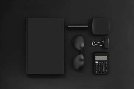 Collection of office accessories in black on black. Creative monochrome business composition of...