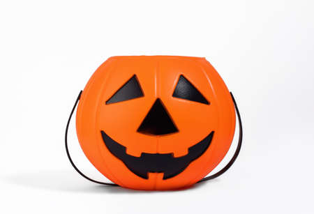 Jack o Lantern orange basket or bucket for sweets isolated on white background with shadow. Halloween celebration and trick-or-treating concept. Sweets collection basketの写真素材