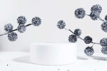Cylindrical podium on a white background with hard shadows and Christmas decorations. Minimal empty cosmetic product presentation scene. Geometric podium. Christmas and New Year conceptの写真素材