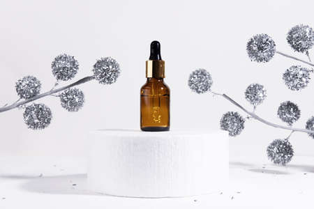 Christmas winter Mock up glass dropper bottle on white podium on white gray background with hard...