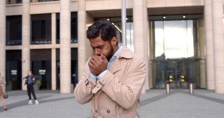 Sick young businessman cough outdoors downtownの写真素材