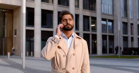 Young handsome businessman talking on phone outdoorsの写真素材