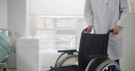 Male nurse pushing an empty wheelchair in hospital wardの写真素材