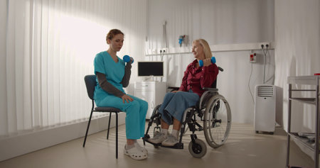 Medical therapist helping disabled senior woman with physiotherapy.の写真素材