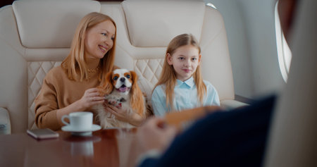 Wealthy family with dog travelling together by private business planeの写真素材