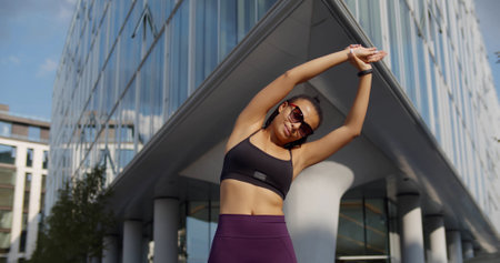 Female runner stretching muscles outdoor at summer morning in cityの写真素材