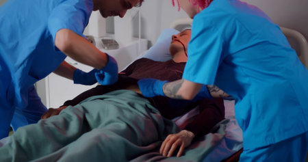 Doctor and nurse cutting shirt of male patient preparing for reanimationの写真素材