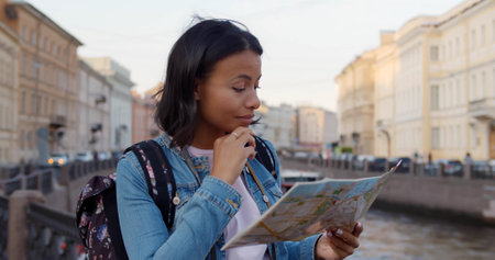 Young happy traveler woman with map on city bridge