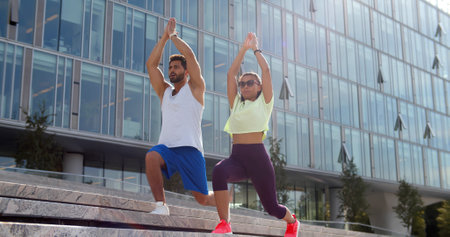 Young couple in sports outfit doing morning workout outdoors on stairs