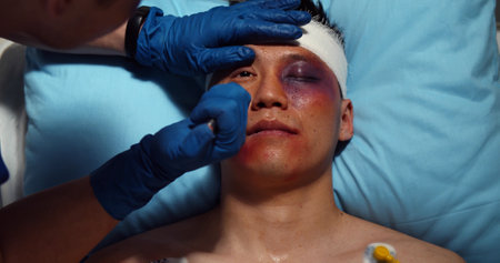 Paramedic checking up and using flashlight on injured young manの写真素材