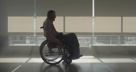 Thoughtful senior man in wheelchair in nursing homeの写真素材