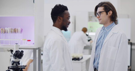 Two diverse scientists working together analyzing discussing innovative technology.の写真素材