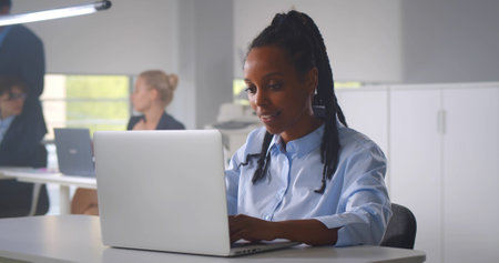 Portrait of a serious businesswoman using laptop in officeの写真素材
