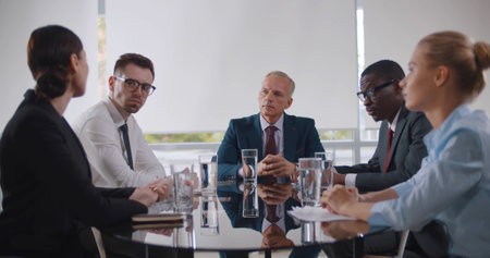 Business leader holding corporate meeting with team in boardroomの写真素材