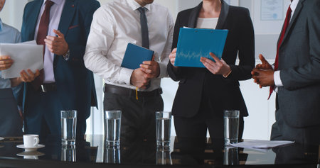 Cropped shot of business people standing in office and discussing documentsの写真素材