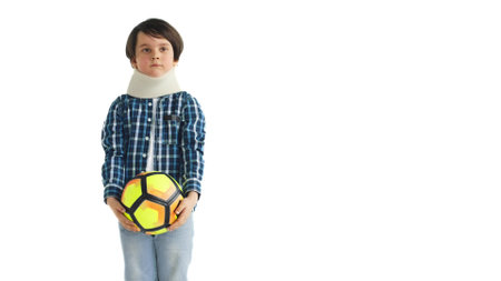 Portrait of preteen boy in neck plaster cast with ball isolated on white backgroundの写真素材