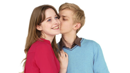 Happy guy hugging and kissing girlfriend in cheek on white background in studio.の写真素材